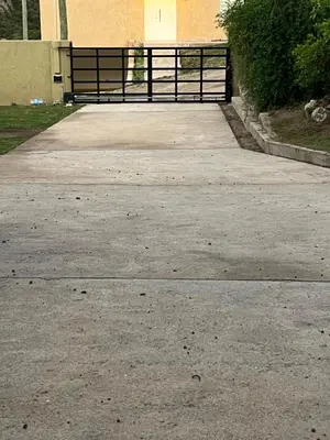 a driveway with a gate in front of a house at Casaabril in Villa Carlos Paz