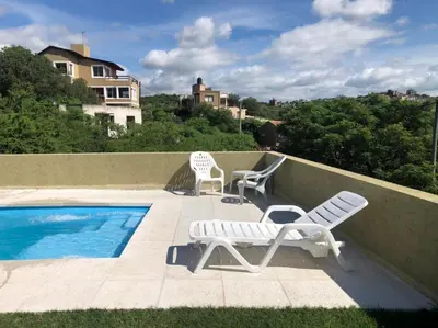 two chairs and a swimming pool on a balcony at Casaabril in Villa Carlos Paz