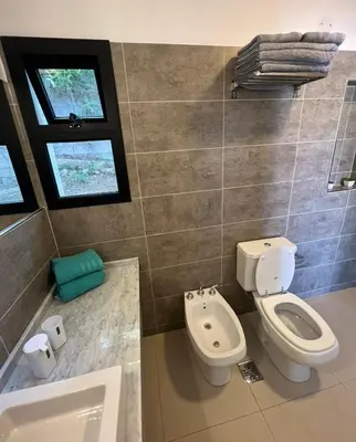 a bathroom with a toilet and a sink and a tub at Casaabril in Villa Carlos Paz