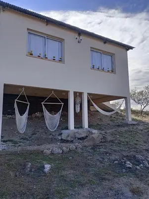 a house with hammocks in front of it at La Tacuarita in Estancia Vieja