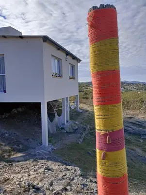a pole with colored stripes next to a house at La Tacuarita in Estancia Vieja