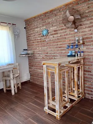 a room with a brick wall and a wooden counter at La Tacuarita in Estancia Vieja