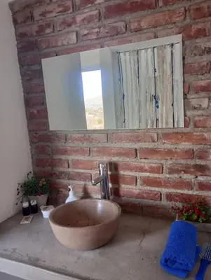 a bathroom with a stone sink and a brick wall at La Tacuarita in Estancia Vieja