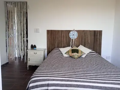 a bedroom with a bed with a black and white striped blanket at La Tacuarita in Estancia Vieja