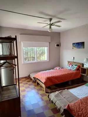 a bedroom with two beds and a ceiling fan at La Mora Casa in Mina Clavero