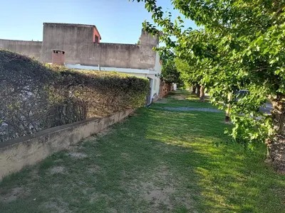 an alley with a fence and a grass field at La Mora Casa in Mina Clavero