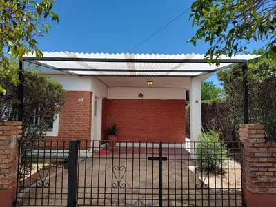 a gate to a house with a brick wall at La Mora Casa in Mina Clavero