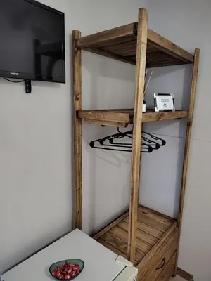 a room with a tv and a wooden shelf at La Mora Departamento in Mina Clavero
