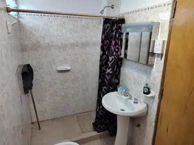a bathroom with a sink and a shower at La Mora Departamento in Mina Clavero