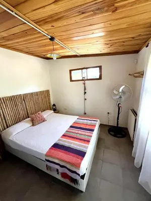 a bedroom with a bed with a wooden ceiling at CASITA PINTORESCA EN LAS SIERRAS Y LAGO in San Roque