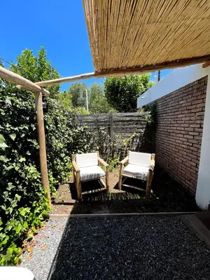 a pair of chairs sitting in a garden at CASITA PINTORESCA EN LAS SIERRAS Y LAGO in San Roque
