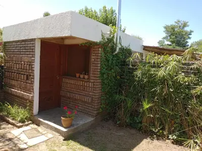 a brick building with a door and some plants at CASITA PINTORESCA EN LAS SIERRAS Y LAGO in San Roque