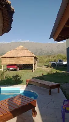 a gazebo with a bench and a swimming pool at EL RANCHO DE PIA in Merlo