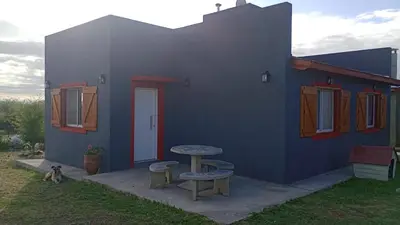 a small blue house with a table and a bench at EL RANCHO DE PIA in Merlo