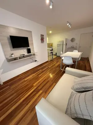 a living room with a tv on the wall and a table at Viaggiato Catamarca in Cordoba