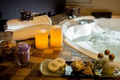 a bathroom with a bath tub with two candles at Domingo Design Hotel in Santa Rosa de Calamuchita