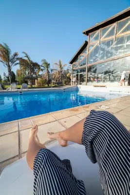 a person laying on the ground next to a swimming pool at Domingo Design Hotel in Santa Rosa de Calamuchita