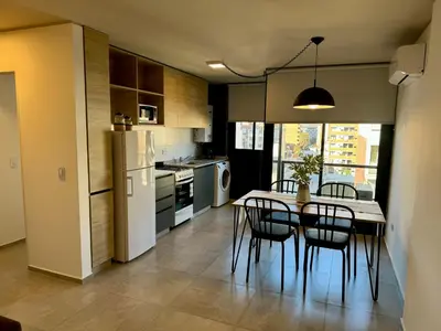 a kitchen with a table and chairs and a refrigerator at Rent a Flat Nueva Cordoba in Cordoba