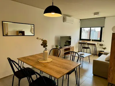 a living room with a wooden table and chairs at Rent a Flat Nueva Cordoba in Cordoba
