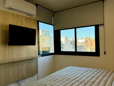 a bedroom with a bed and a flat screen tv at Rent a Flat Nueva Cordoba in Cordoba
