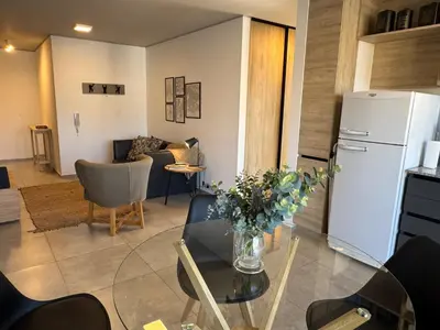 a kitchen and living room with a table and a refrigerator at Rent a Flat Nueva Cordoba in Cordoba