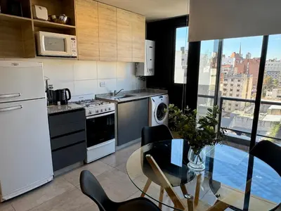 a kitchen with a table and a kitchen with a view at Rent a Flat Nueva Cordoba in Cordoba
