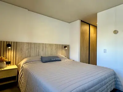 a bedroom with a large bed and a wooden wall at Rent a Flat Nueva Cordoba in Cordoba