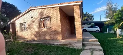 a brick house with a car parked in the driveway at Don Edelmi in Villa Carlos Paz