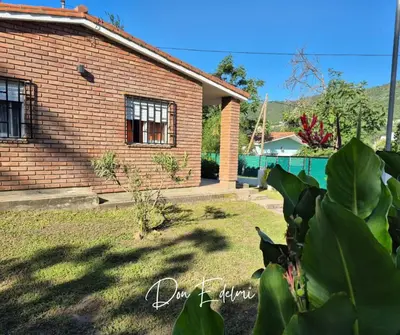 a brick house with a yard in front of it at Don Edelmi in Villa Carlos Paz