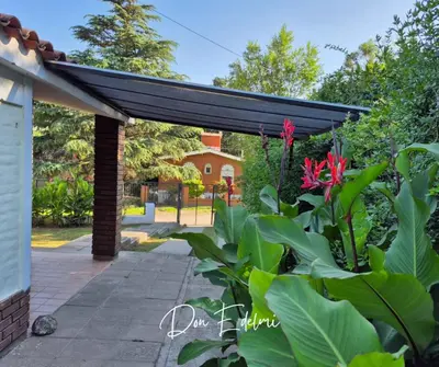 awning over a patio with plants and flowers at Don Edelmi in Villa Carlos Paz