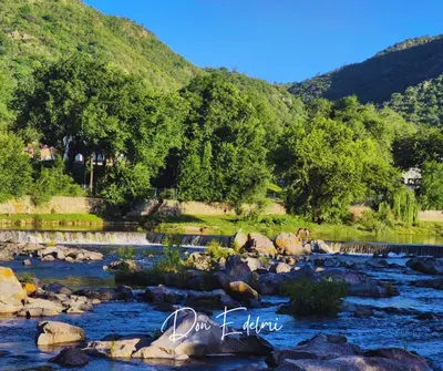 a river with rocks and mountains in the background at Don Edelmi in Villa Carlos Paz