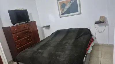 a bedroom with a bed and a tv on a dresser at Don Edelmi in Villa Carlos Paz