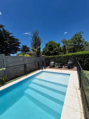 a swimming pool with blue water in a yard at Don Edelmi in Villa Carlos Paz