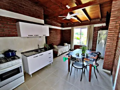 a kitchen and living room with a table and a stove at Departamento Olmos in Mina Clavero