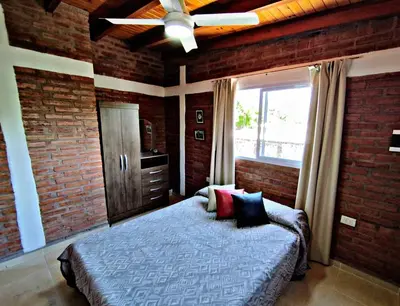 a bedroom with a bed and a ceiling fan at Departamento Olmos in Mina Clavero