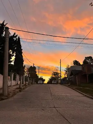 an empty street with a sunset in the sky at Departamento Olmos in Mina Clavero