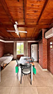 a dining room with a table and chairs and a bed at Departamento Olmos in Mina Clavero