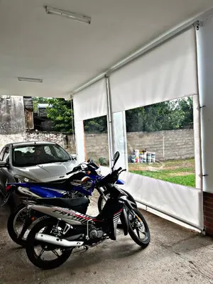 a motorcycle parked in a garage next to a car at Departamento Olmos in Mina Clavero