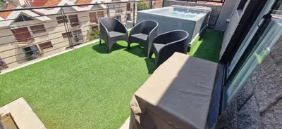 a balcony with chairs and a table and grass at Vivisierras, Piso 4 frente al lago Centro Villa Carlos Paz, pileta privada, vista panorámica in Villa Carlos Paz