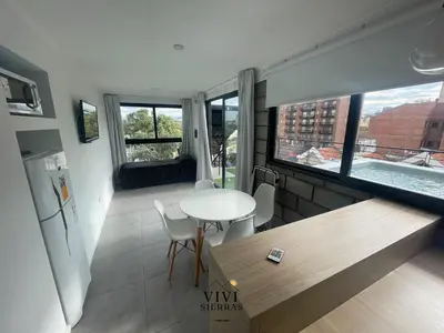 a living room with a table and a kitchen with a window at Vivisierras, Piso 4 frente al lago Centro Villa Carlos Paz, pileta privada, vista panorámica in Villa Carlos Paz