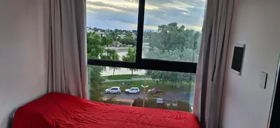 a bedroom with a large window looking out at a street at Vivisierras, Piso 4 frente al lago Centro Villa Carlos Paz, pileta privada, vista panorámica in Villa Carlos Paz