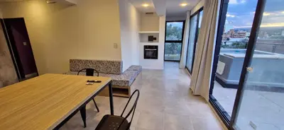a room with a table and chairs and a balcony at Vivisierras, Piso 3 frente al lago, centro Villa Carlos Paz, 2 dormitorios, 2 baños, pileta privada, premium in Villa Carlos Paz
