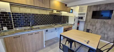 a kitchen with a sink and a table with chairs at Vivisierras, Piso 3 frente al lago, centro Villa Carlos Paz, 2 dormitorios, 2 baños, pileta privada, premium in Villa Carlos Paz