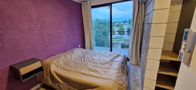 a bedroom with a bed and a large window at Vivisierras, Piso 3 frente al lago, centro Villa Carlos Paz, 2 dormitorios, 2 baños, pileta privada, premium in Villa Carlos Paz