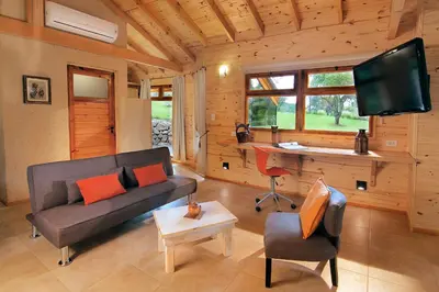 a living room with a couch and a desk at Cabañas Sierra Serena in Villa General Belgrano