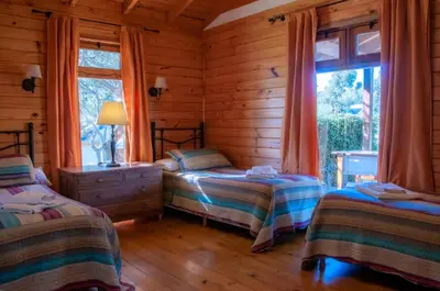 a bedroom with two beds in a log cabin at Cabañas Sierra Serena in Villa General Belgrano