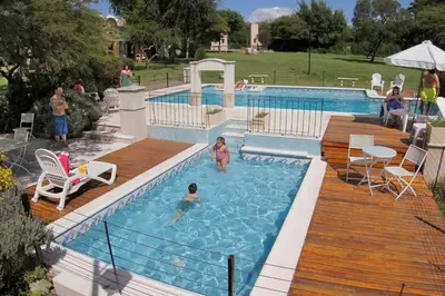 a pool with two children playing in the water at Cabañas Sierra Serena in Villa General Belgrano