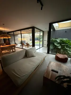 a living room with a white couch and a large window at RumaRanch Solo Parejas Casa con pileta privada a 20 mts del Río in Villa Carlos Paz