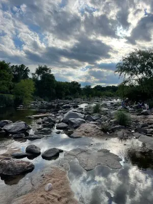 a river with rocks and clouds in the water at RumaRanch Solo Parejas Casa con pileta privada a 20 mts del Río in Villa Carlos Paz