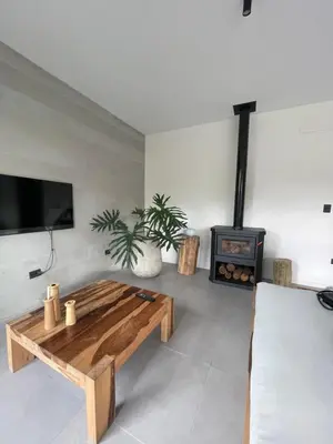 a living room with a wooden coffee table and a fireplace at RumaRanch Solo Parejas Casa con pileta privada a 20 mts del Río in Villa Carlos Paz